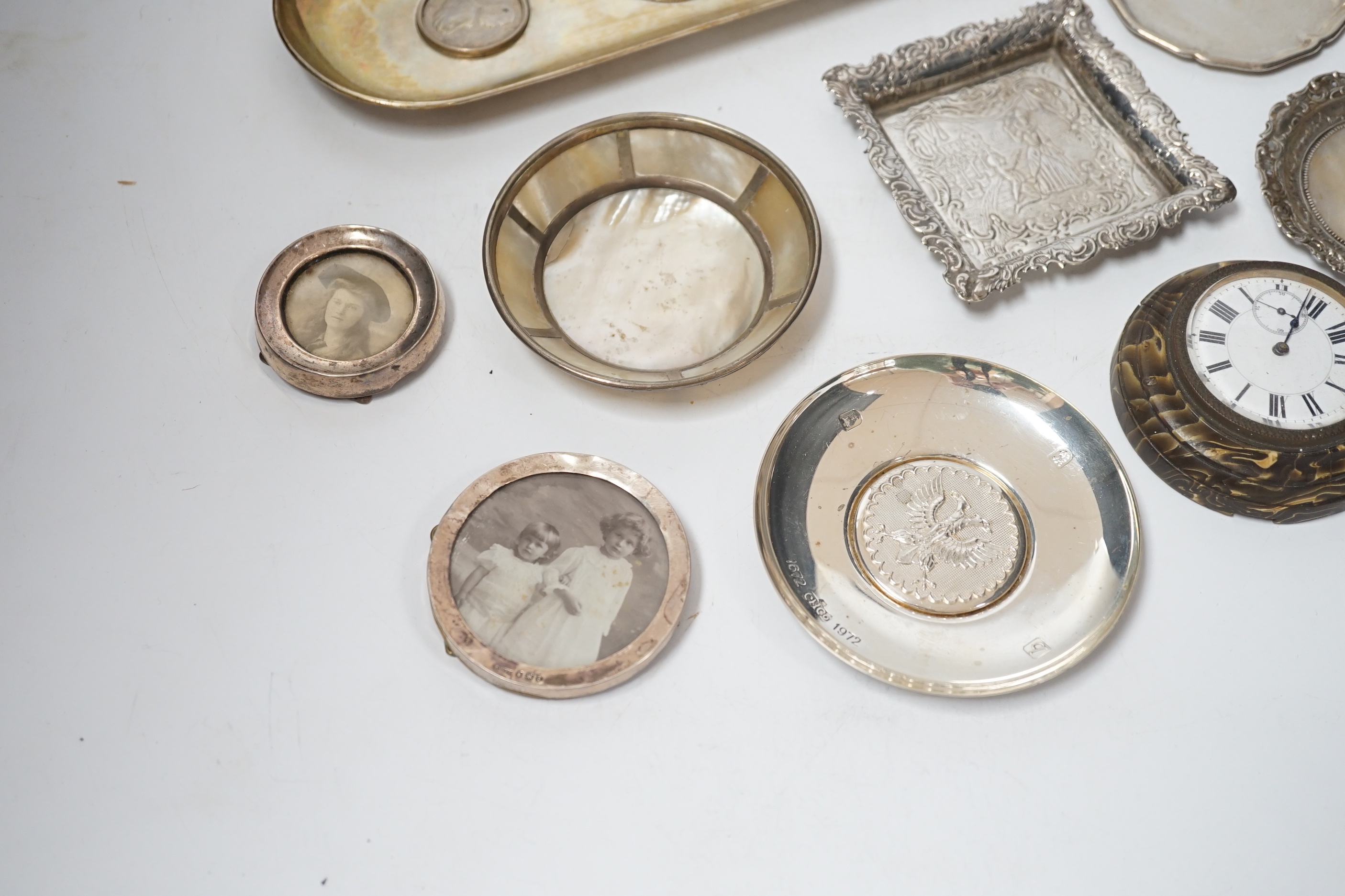 Sundry small silver and white metal items including seven photograph frames, largest 12.5cm, an 800 standard oval dish, inset with three coins, five small dishes and a timepiece.